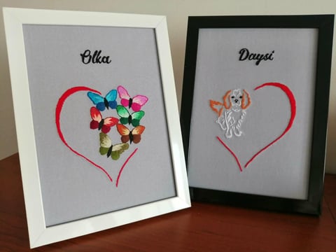 Two framed hand-drawn artworks with names Olka and Daysil, each featuring a red heart outline with flowers and a dog illustration inside.