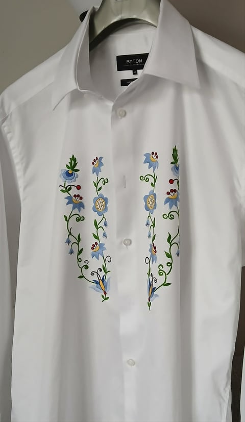 White dress shirt by BYTOM with blue and green floral embroidery on front placket, hung on hanger