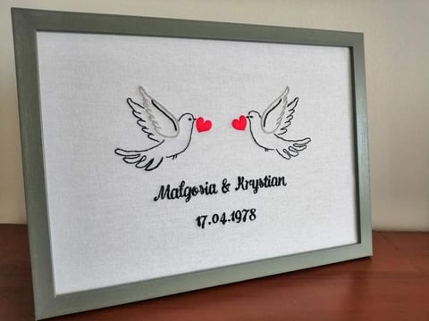 Framed artwork with two doves facing each other, red hearts between them, and names Malgoria and Arystian with date 17.04.1978