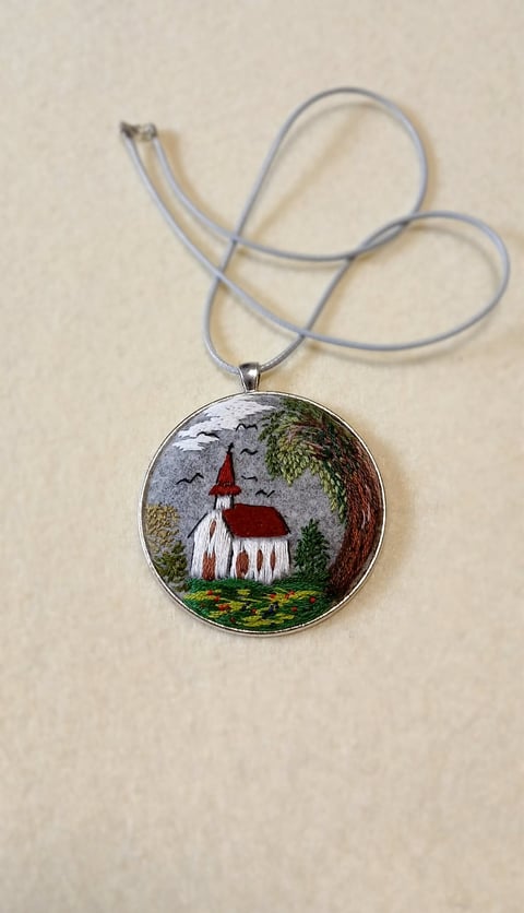 Embroidered pendant necklace featuring a tiny gnome with red hat and white beard on gray cord