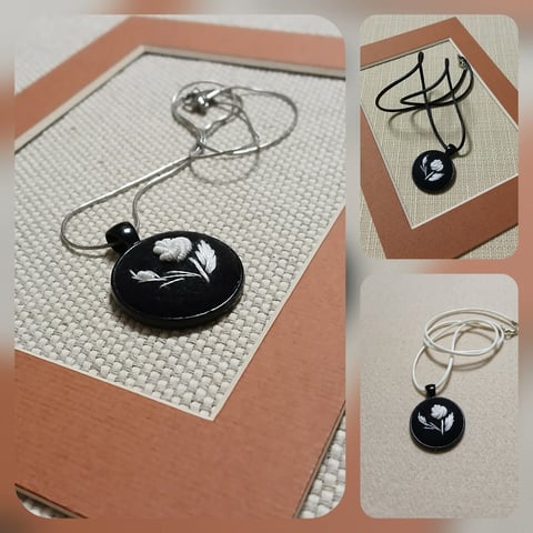 Black pendant necklace with white cord shown in multiple angles on paper backgrounds